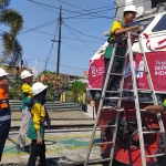 Kepala Daerah Operasi PT PT KAI Daop 7 Madiun, Suharjono, memeriksa pelaksanaan menghias lokomotif. Foto: HENDRO SUHARTONO/ BANGSAONLINE