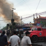 Asap tampak membumbung tinggi dari dari Kelenteng Poo An Kiong yang Terbakar. foto: AKINA/ BANGSAONLINE