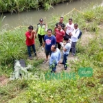 Petugas bersama warga hendak mengevakuasi mayat yang ditemukan di dalam koper. foto: AKINA/ BANGSAONLINE