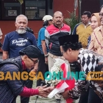 Dolik Lana, korlap aksi, saat menyerahkan buket bunga kepada anggota Bawaslu Kota Kediri, Suhartono, yang didampingi Ketua Bawaslu Kota Kediri, Yudi Agung Nugroho. Foto: MUJI HARJITA/ BANGSAONLINE