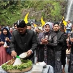 Bupati Marhaen Djumadi memotong tumpeng usai pelaksanaan mandi siraman Sedudo. Foto: BAMBANG/ BANGSAONLINE.com
