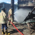 Petugas Damkar Gresik saat melakukan pembasahan terhadap warkop yang terbakar. Foto: Ist.