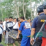 Aris Sugiarto (34) menangis saat memperagakan satu adegan reka ulang di jembatan Karanggondang, Udanawu, Kabupaten Blitar, Rabu (24/4/2019). foto: AKINA/ BANGSAONLINE