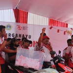 Kades Randuagung, Khambali, menunjukkan kupon saat pengundian hadiah utama jalan sehat berupa 1 unit sepeda motor. Foto: Ist.