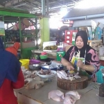 Listikah, salah satu penjual daging ayam di pasar tradisional Tuban sedang melayani pembeli.