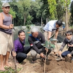 Koordinator EPPI, Beny Prasetya (pegang pohon), bersama relawan saat menanam pohon karet kebo merah di area Sumber Kweden, Desa Karangrejo, Kecamatan Ngasem, Kabupaten Kediri. Foto: MUJI HARJITA/ BANGSAONLINE