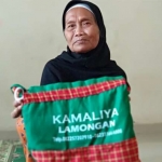 Nenek Jimani menunjukkan tas haji yang didapatkannya.