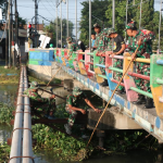 Personel TNI dan warga membersihkan sungai di Desa Penambangan Balongbendo, Minggu (12/5/2024)