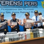 Petugas saat menunjukkan barang bukti rokok ilegal sebelum dimusnahkan.