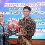 Gubernur Khofifah saat menerima helm motif batik Telaga Sarangan dari Mario Suryo Aji.