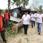 Bupati Malang Sanusi membawakan buah semangka untuk pekerja proyek pengerjaan ruas jalan di jalur Gondanglegi menuju Pantai Balekambang.