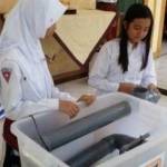 Dua siswi SDN 1 Kranggan saat sedang memperagakan penemuan mesin pencuci telur hemat biaya dan waktu. foto istimewa