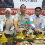 Ketua DPC Gerindra Gresik, Asluchul Alif, bersama sekretarisnya, Nur Saidah, dan Lutfi Dhawam selaku bendahara saat memotong tumpeng. Foto: SYUHUD/BANGSAONLINE