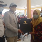 Bupati Pasuruan H. M. Irsyad Yusuf (dua dari kiri) saat menyerahkan bantuan untuk korban banjir bertempat di Balai Desa Kepulungan, Jum