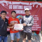 Pimpinan Perusahaan BANGSAONLINE Revol Afkar (tengah) didampingi Ketua Panitia Budi Rahmad (kiri), menyerahkan hadiah kepada juara 1 lomba mancing. Foto: YUSUF/ BANGSAONLINE