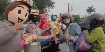 Spiderman dan Polisi Lalu Lintas Bagikan Snack dan Masker ke Pengendara di Sidoarjo