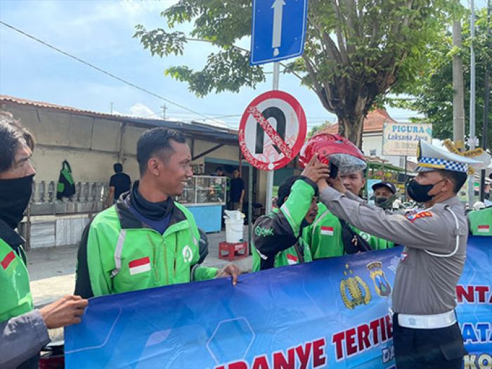 Bagikan Helm Gratis, Polres Mojokerto Kota Ajak Komunitas Ojol Tertib Berlalu Lintas