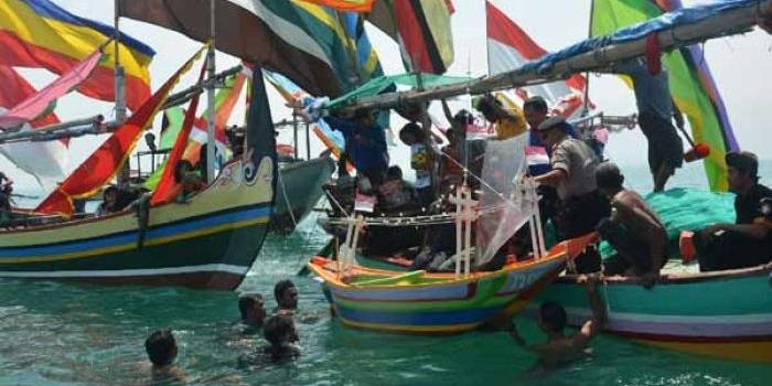 Para nelayan beserta perahunya saat meletakkan sesaji di tengah laut. foto: suwandi/ BANGSAONLINE