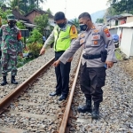 Polisi bersama warga sedang menunjuk ke titik lokasi kecelakaan.