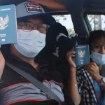 Agus Erijanto bersama istrinya menunjukkan paspor yang diambil dari Layar Karmila.