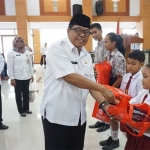 Wakil Wali Kota Blitar Santoso saat membagikan seragam kepada sejumlah siswa siswi SD dan SMP. foto: AKINA/ BANGSAONLINE