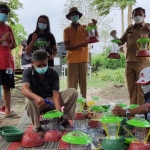 Kepala Kelurahan Burengan Adi Sutrisno (berdiri paling kanan) bersama beberapa warga RT 01 RW 12, saat memamerkan hasil karyanya berupa lampu hias dari bahan plastik bekas. Foto: Muji Harjita/ BANGSAONLINE.com
