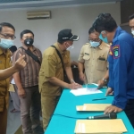 Panitia Pilkades Kabupaten Pasuruan saat menyerahkan hasil tes baca tulis dan membaca kitab suci di kantor dinas perumahan dan kawasan permukiman.