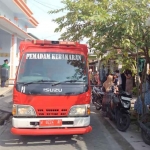 Petugas Damkar Gresik saat memadamkan kobaran api di rumah Ahmad Adim yang dilalap si jago merah. Foto: Ist
