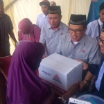 Dari kiri ke kanan berkopyah, Direktur Enjinering dan Proyek Semen Indonesia Aunur Rosyidi, Direktur Produksi dan Pengembangan Bisnis Johan Samudra dan Direktur Utama Semen Gresik Sunardi Prionomurti ikut melayani pembeli pada pasar murah yang digelar Semen Indonesia. foto: SYUHUD/ BANGSAONLINE