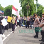 Ratusan pendemo saat berorasi sambil membentangkan poster di depan Mapolres Jombang. foto: AAN AMRULLOH/ BANGSAONLINE