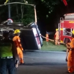 Petugas saat mengevakuasi mobil yang tercebur di Jalan Jemursari, Surabaya.