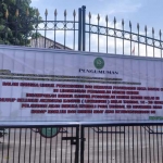 Papan pengumuman lockdown yang terpasang di pintu masuk Kantor PN Kota Kediri. 