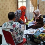 Tim penyidik saat melakukan penggeledahan di Kecamatan Pucuk. (foto: ist).