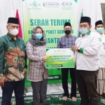 Niluh Sumadewi dari PT Siantar Top, Tbk secara simbolis menyerahkan bantuan 500 paket sembako kepada Wakil Ketua PCNU Kota Surabaya, Muhammad Yazid di Kantor PCNU Kota Surabaya, Jl. Bubutan. foto: istimewa