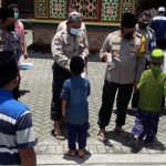 Kapolresta Sidoarjo bersama pejabat utama membagikan masker dan susu sebelum pelaksanaan Salat Jumat. (foto: ist)