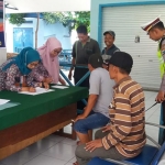 Petugas Dinkes didampingi Kasatlantas Polres Mojokerto Kota memeriksa awak bus jelang momen Nataru. 