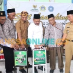 Bupati Gresik, Fandi Akhmad Yani memasukkan uang di kota zakat saat hadiri launching Kampung Zakat Produktif di Desa Gredek, Selasa (18/10/2022). Foto: SYUHUD/BANGSAONLINE.com