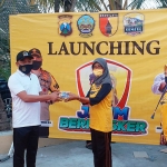 H. Syafiuddin memberikan masker kepada salah satu warga Perum Griya Abadi saat launching Jatim Bermasker di Rumah Tanggap Covid-19, Perum Griya Abadi Bangkalan, Kamis (6/8/2020).
