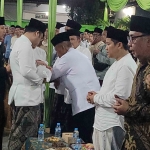 Cucu Prof Dr KH Asep Saifuddin Chalim, Fadhilah Zemirah Tufafa Chalim, digendong ayahnya, Gus Fadil, digunting rambutnya oleh Prof Dr KH Ridwan Nasir,  dalam acara walimatul aqiqah di Pondok Pesantren Amanatul Ummah Surabaya, Sabtu (13/10/2024) tadi malam. Foto: MMA/bangsaonline