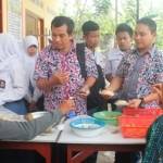 SIDAK: Tiga petugas Dinkes Bojonegoro saat melakukan sidak jajanan sekolah di SMA Negeri Baureno, Rabu (4/3). Foto: Eky Nurhadi/BangsaOnline.