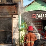 Petugas pemadam kebakaran saat melakukan pemadaman di sebuah rumah usaha laundry yang berada di Dusun Demeling, Desa/Kecamatan Gedangan, Sidoarjo. 