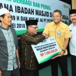 Direktur Keuangan, SDM, dan Umum PG Dwi Ary Purnomo didampingi Wabup Gresik Moh. Qosim saat memberikan bantuan.