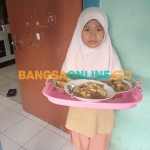 Seorang anak-anak di Probolinggo saat melakukan Ter Ater Tajin Sorah atau istilah dalam Bahasa Madura. Foto: SUGIANTO/BANGSAONLINE