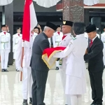 Pj Bupati Nganjuk Sri Handoko Taruna saat menyematkan sabuk dalam pengukuhan Paskibraka 2024. 
