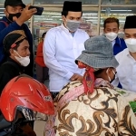 Muhammad Al-Barra (Gus Bara, baju putih) saat memberikan beras dan mie instan di kepada salah seorang di sentra PKL di Kecamatan Jetis Mojokerto, Ahad (25/7/2021). Tampak ia didampingi Ali Mannagali Parawansa (juga baju putih), putra bungsu Gubernur Jawa Timur Khofifah Indar Parawansa. Foto: MMA/ BANGSAONLINE.com