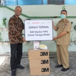 Humas dan Jubir EMCL, Rexy Mawardijaya saat menyerahkan masker N95 secara simbolis kepada Dinkes Bojonegoro.