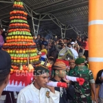 Dua gunungan hasil bumi serta satu kepala sapi diarak di bibir Pantai Tambakrejo sebelum dilarung ke tengah laut.