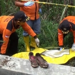 Petugas saat mengevakuasi jenazah korban.