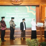 Gubernur Jawa Timur Khofifah Indar Parawansa saat menyerahkan bonos kepada salah satu perserta MTQ berprestasi di Gedung Negara Grahadi Surabaya, Kamis (4/2/2021). Foto: ist/bangsaonline.com