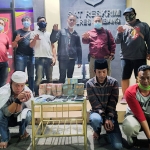 Para tersangka (jongkok) sesaat setelah diamankan di Mapolres Jombang bersama barang bukti berupa segepok uang tunai.